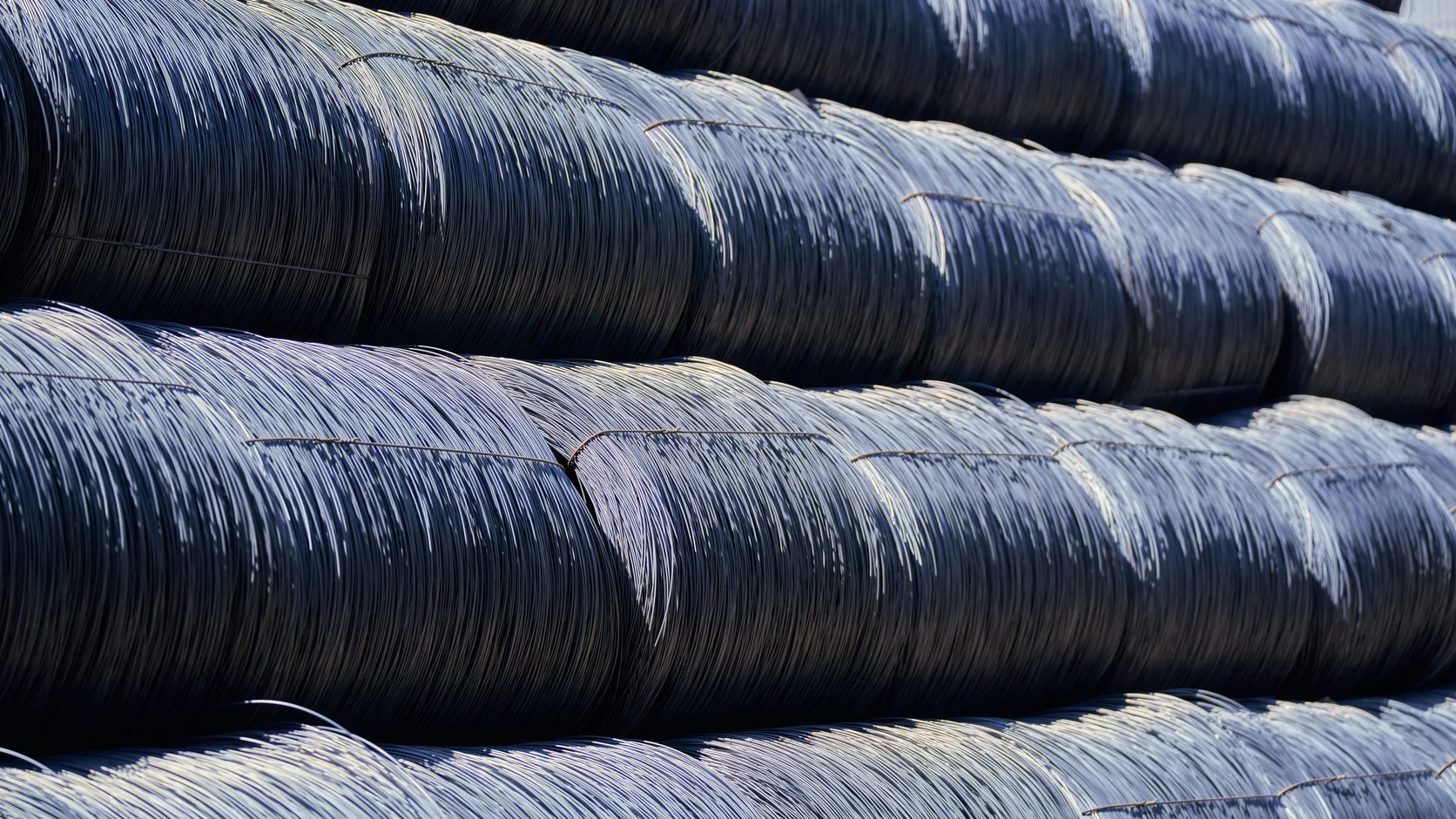 Photograph of tightly wound steel wire coils stacked outdoors